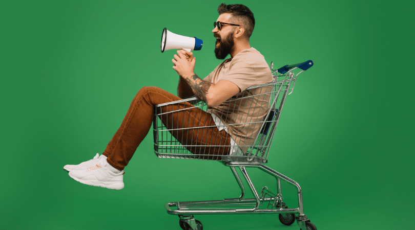 Man sitting in a shopping trolley with a bullhorn